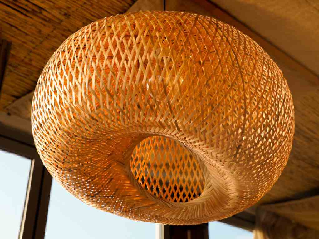 Large woven bamboo pendant lamp beneath a bamboo ceiling